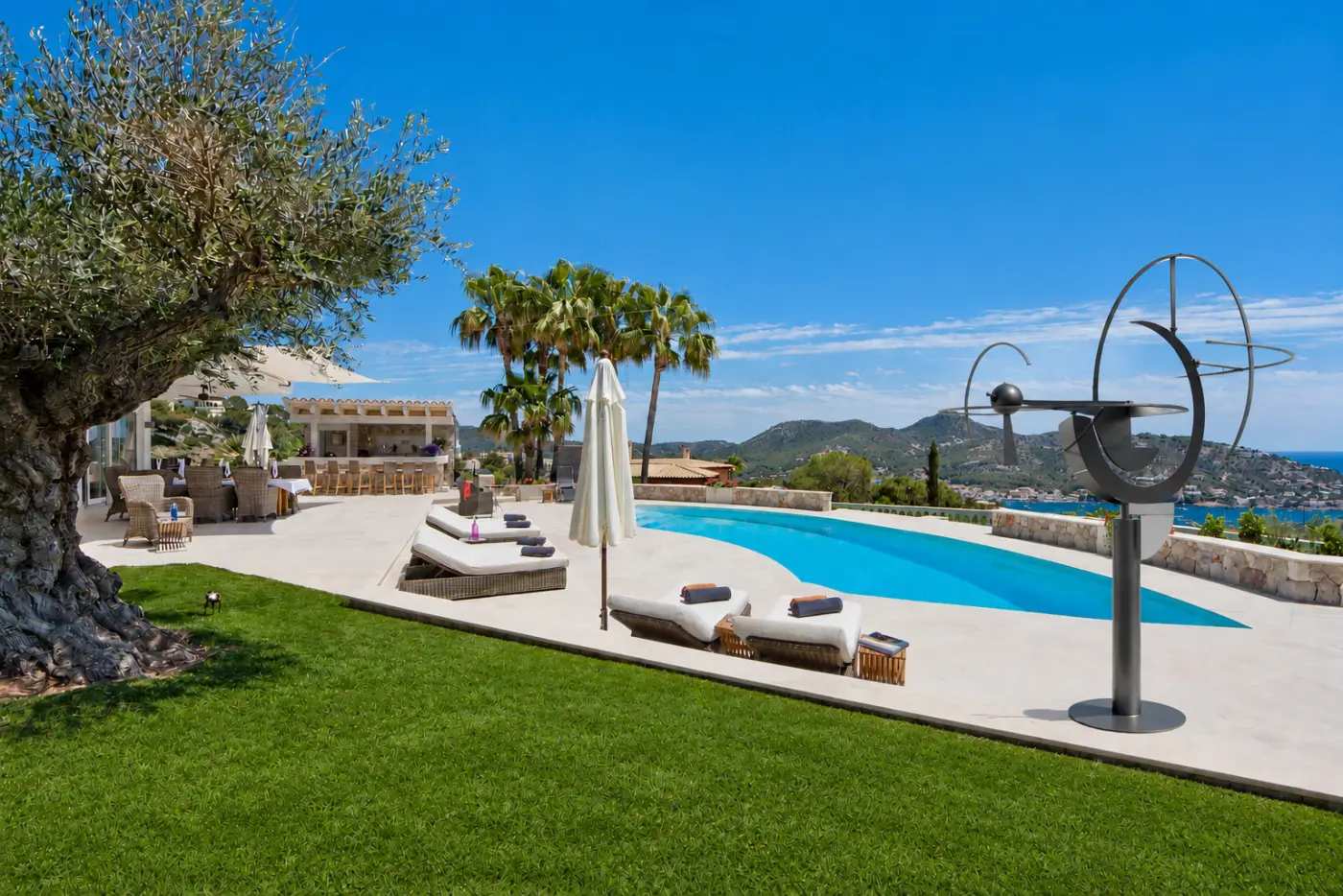 Kinetische Stahlskulptur auf einer Poolterrasse mit Blick über die Bucht von Andratx